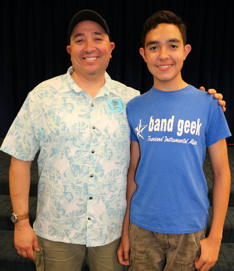 Military veteran Al Mora and his junior high age son Ezekiel stand side by side, smiling Military veteran Al Mora and his junior high age son Ezekiel stand side by side, smiling